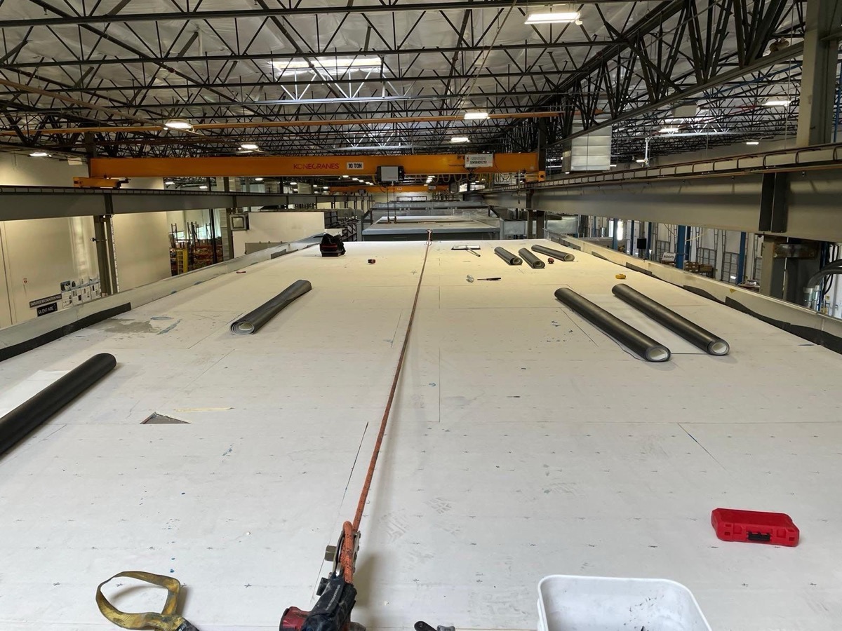 Membrane and materials staged across a large industrial roof deck